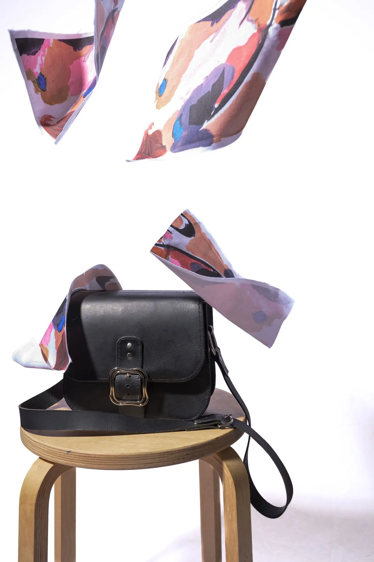photo d'un sac en cuir sur lequel tombent des tissus